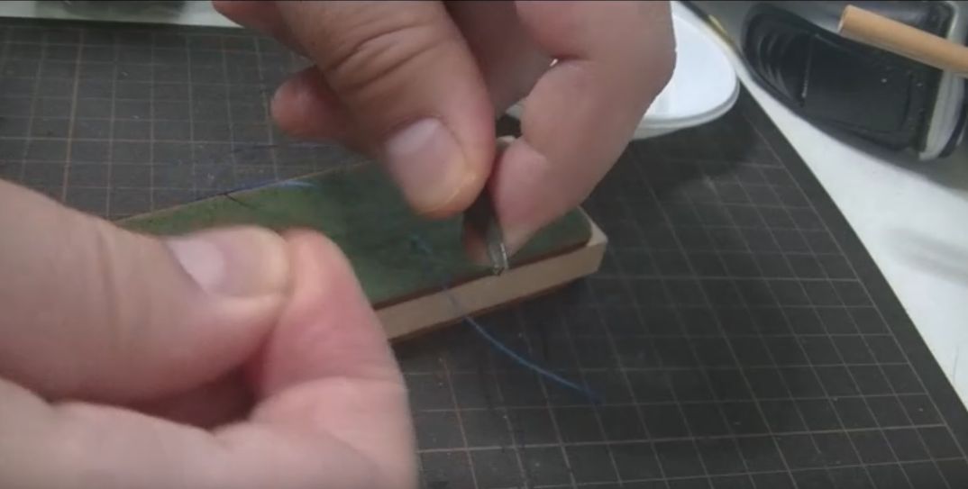 ポリエステル糸でヘリ落としの先端を研磨する様子