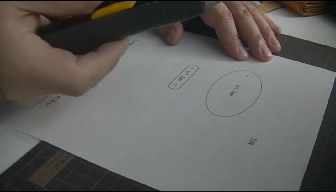 レザークラフトの型紙をカッターで大まかに切り出す様子