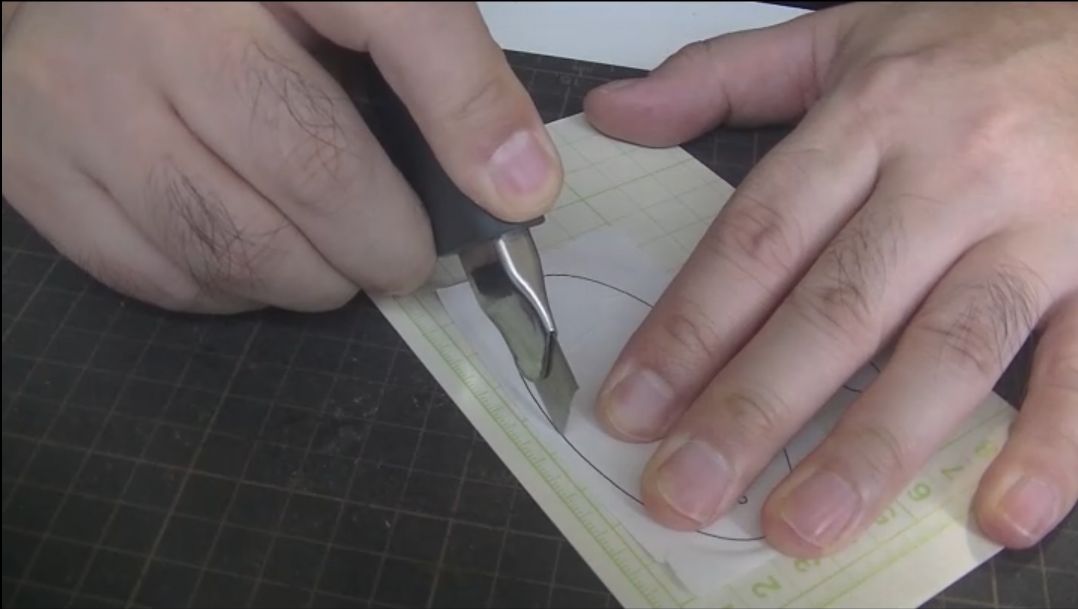 厚紙に貼った型紙を切り出す様子