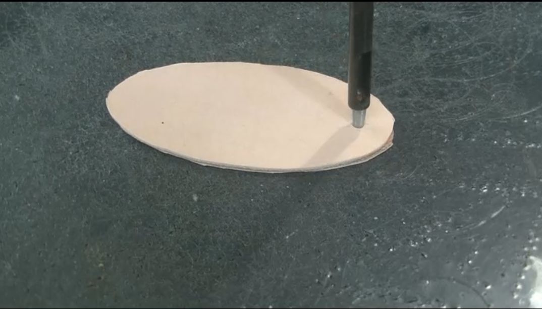 キーホルダー本体にカシメの穴を開ける様子