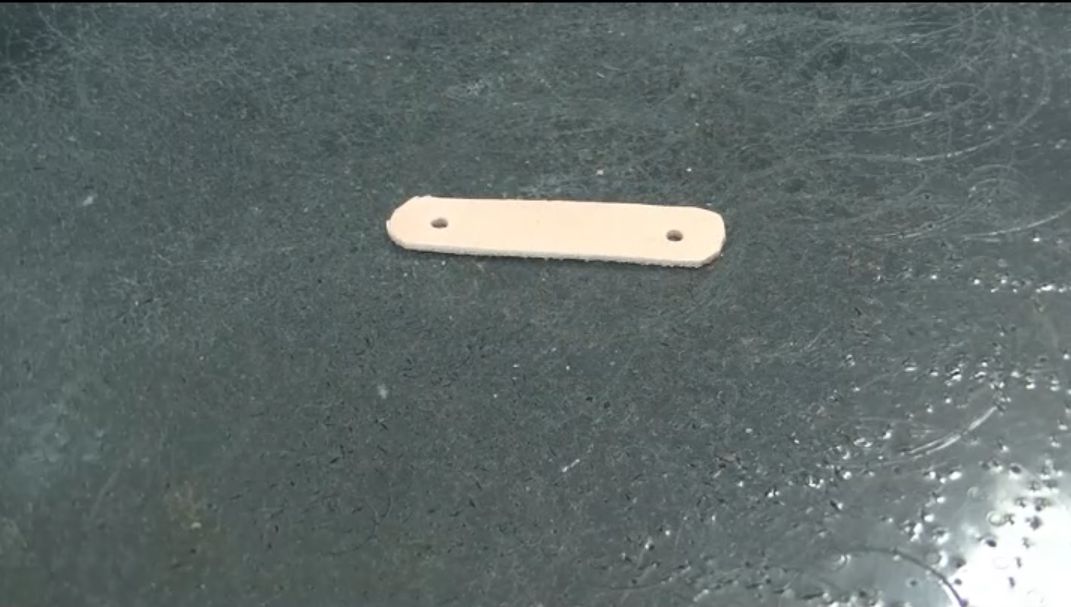 キーリングの革にカシメの穴を開ける様子