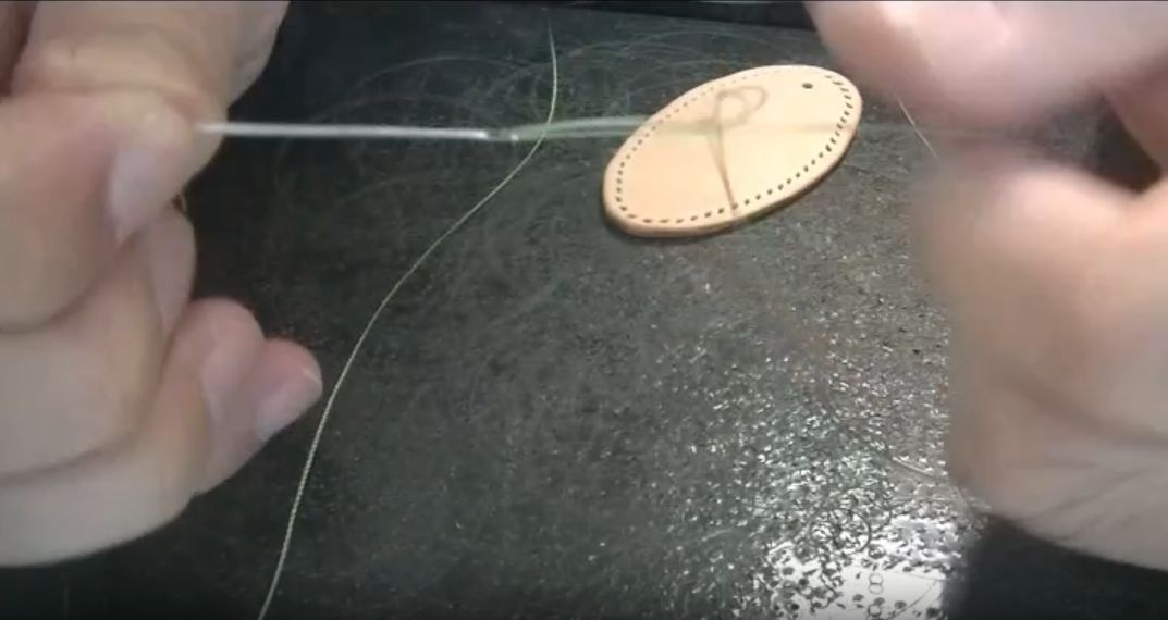 縫い針にポリエステル糸を取り付ける様子