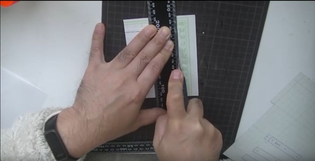 厚紙に貼った型紙を切り出す様子