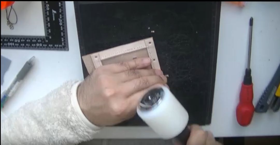 ハトメ抜きで穴を開ける様子