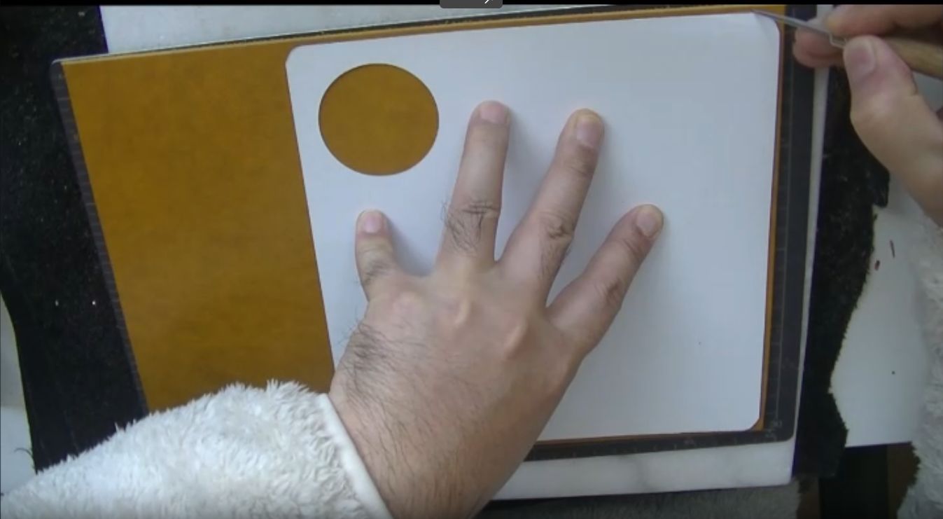 型紙を使って革に目打ちで印をつける様子