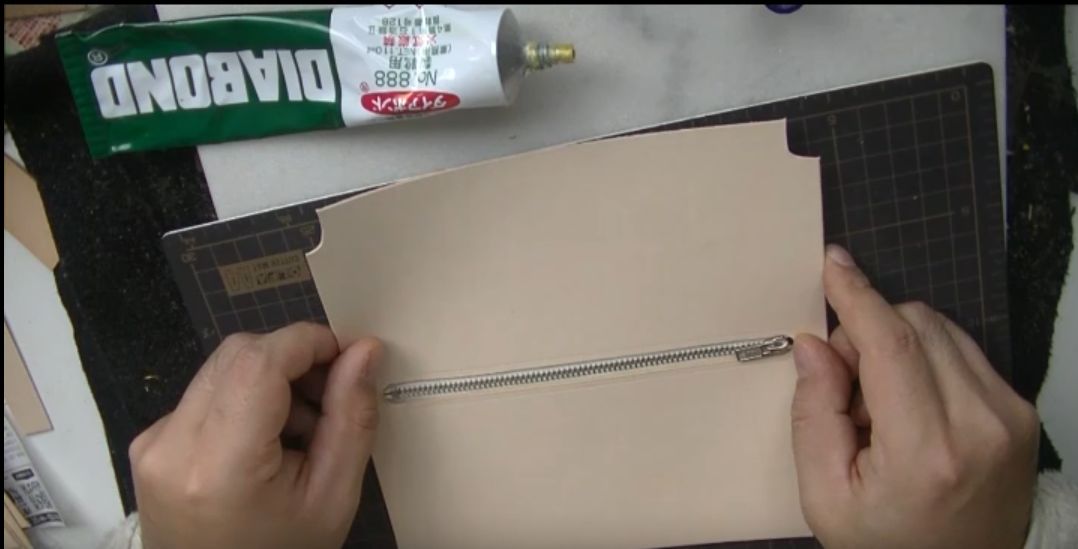 ファスナーをコインケースに貼り付ける様子