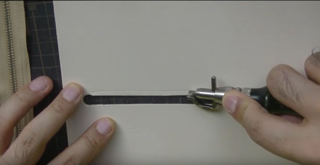 コインケースにステッチンググルーバーで縫い代を引く様子